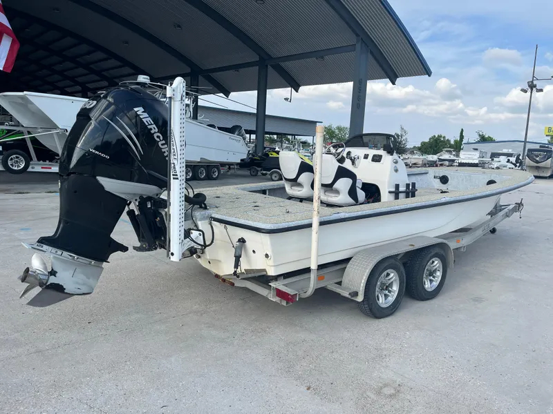 Slide: The Image of 2013 Haynie 24 HO boat on trailer with Mercury outboard motor, parked under a canopy. - 7