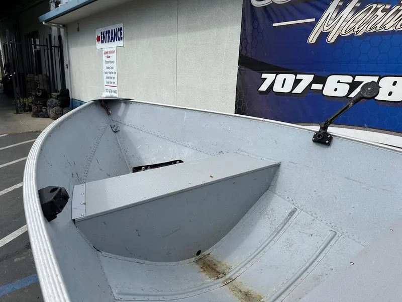 Slide: The Image of 2022 Lund WC-14 boat interior, parked near a building with signage. - 13