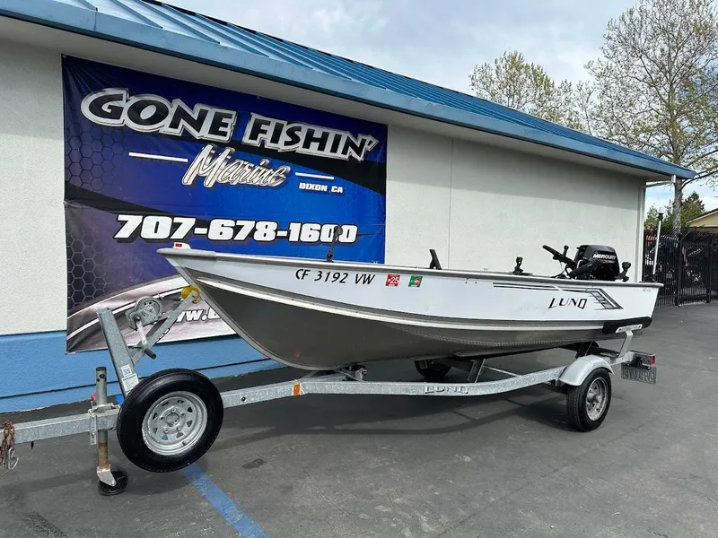 Slide: The Image of 2022 Lund WC-14 boat on trailer outside Gone Fishin' Marine store. - 2