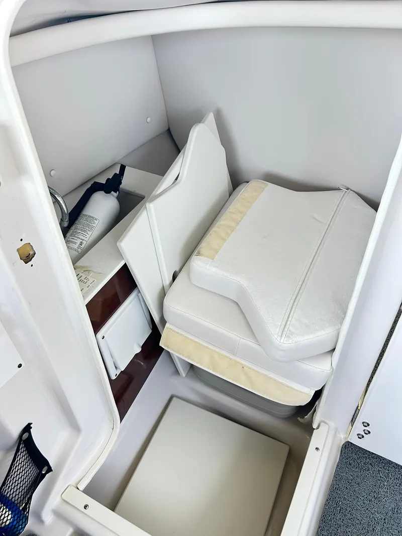 Slide: The Image of 2016 Scarab 255 H.O. Platinum boat interior storage with cushions and fire extinguisher. - 19