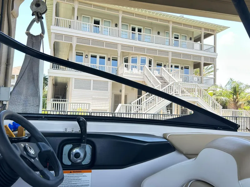 Slide: The Image of Interior view of 2016 Scarab 255 H.O. Platinum boat with a multi-story building in the background. - 24