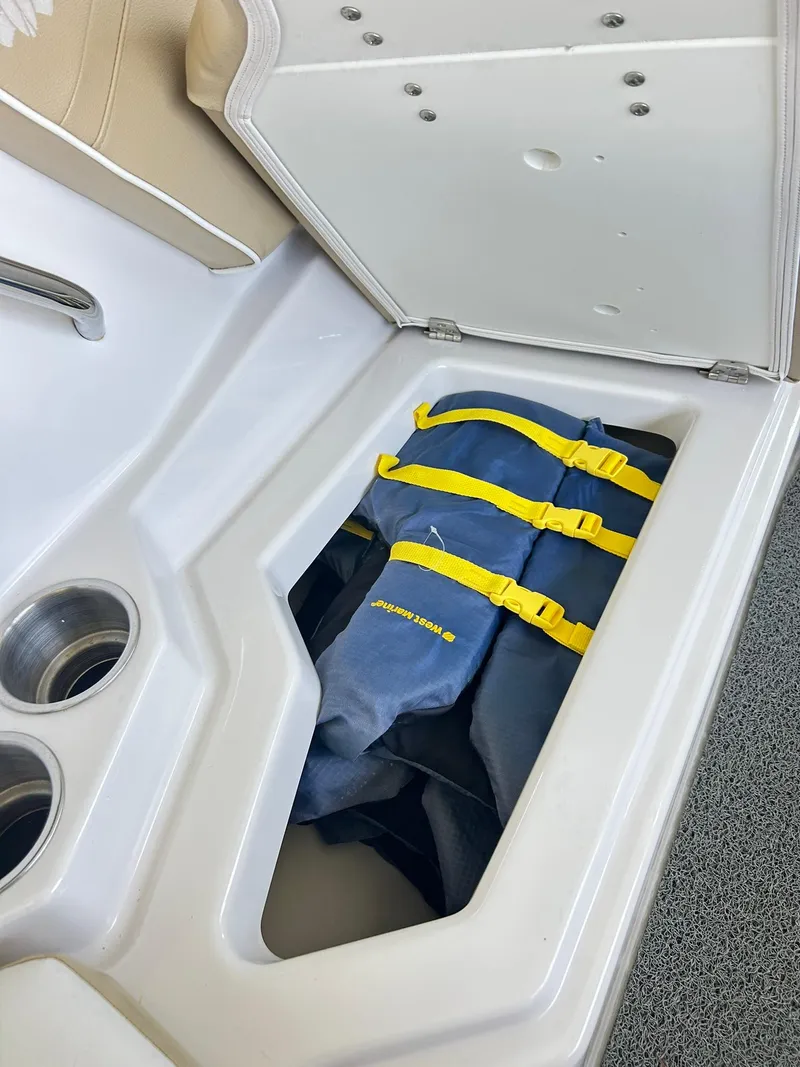 Slide: The Image of Storage compartment with life jackets in a 2016 Scarab 255 H.O. Platinum boat. - 27