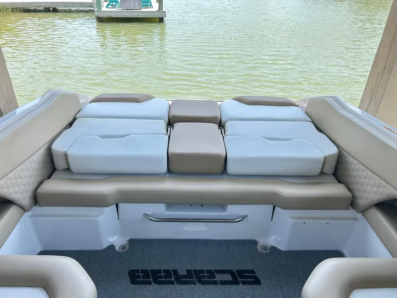 Slide: The Image of 2016 Scarab 255 H.O. Platinum boat interior with cushioned seating by the water. - 30