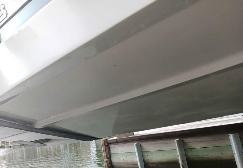 Slide: The Image of 2016 Scarab 255 H.O. Platinum boat hull near dock. - 44
