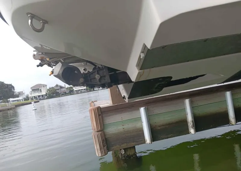 Slide: The Image of 2016 Scarab 255 H.O. Platinum boat on lift by waterfront homes. - 45