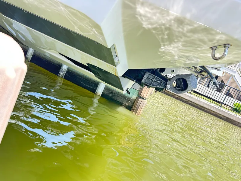 Slide: The Image of 2016 Scarab 255 H.O. Platinum boat partially submerged in greenish water near a dock. - 49