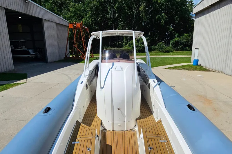 Slide: The Image of 2012 Cougar R10 Rigid Inflatable boat with sleek design, docked near a storage facility. - 11
