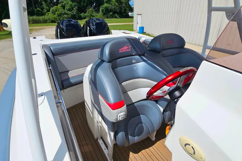 Slide: The Image of 2012 Cougar R10 Rigid Inflatable boat interior with red steering wheel and dual seats. - 17