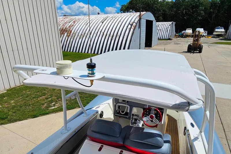 Slide: The Image of 2012 Cougar R10 Rigid Inflatable boat with canopy, parked near industrial buildings. - 23