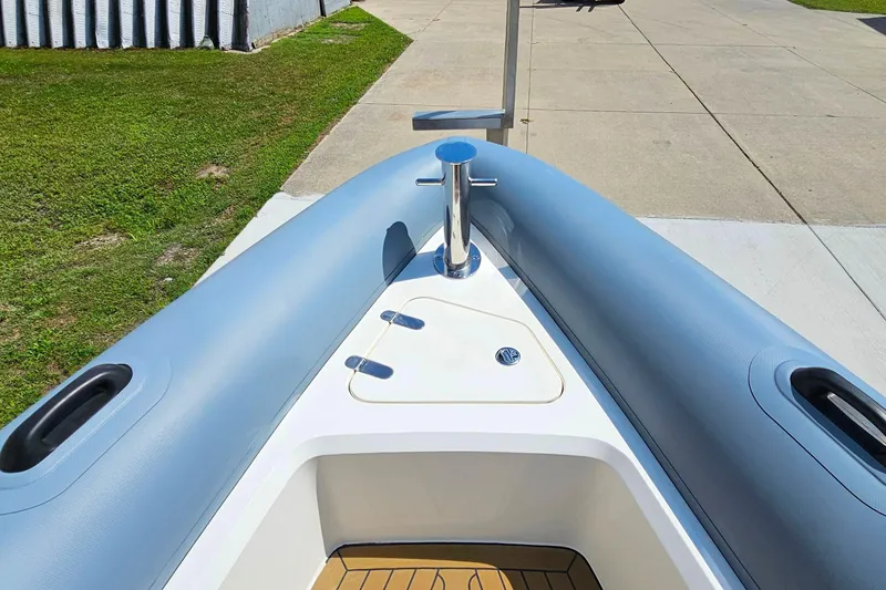 Slide: The Image of 2012 Cougar R10 Rigid Inflatable boat bow, docked on concrete and grass. - 33