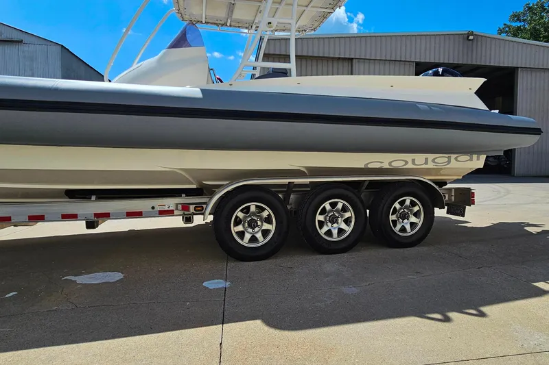 Slide: The Image of 2012 Cougar R10 Rigid Inflatable boat on trailer, parked outside a warehouse. - 34