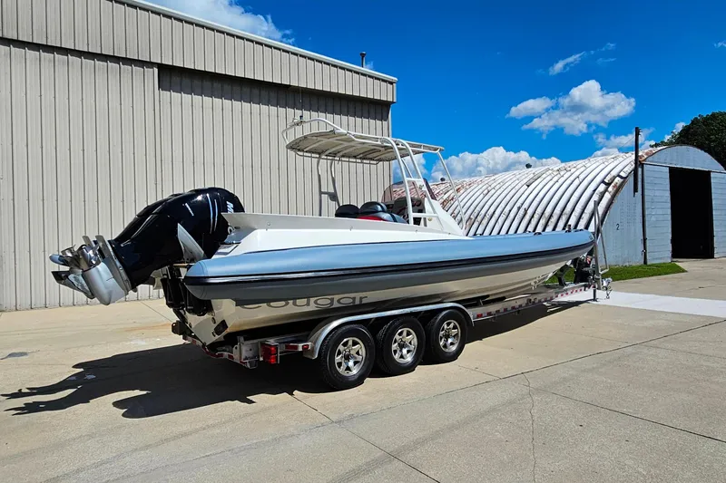 Slide: The Image of 2012 Cougar R10 Rigid Inflatable boat on trailer, parked outdoors under blue sky. - 36
