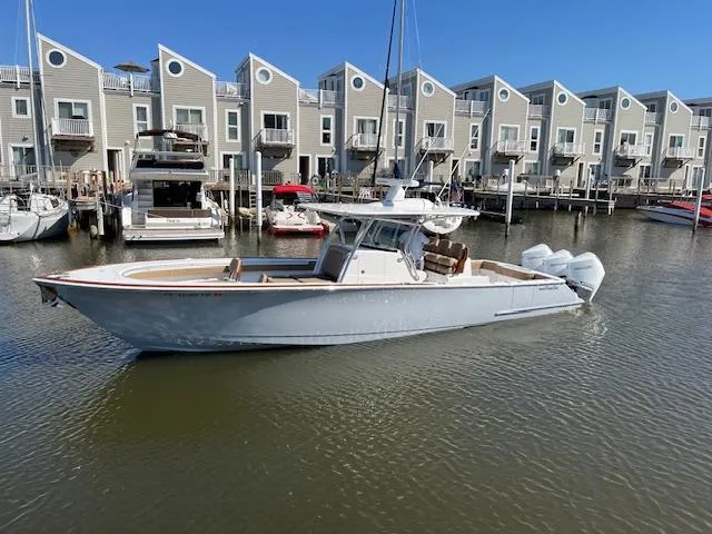 Slide: The Image of 2022 Valhalla Boatworks V-37 in marina, modern townhouses in background. - 6