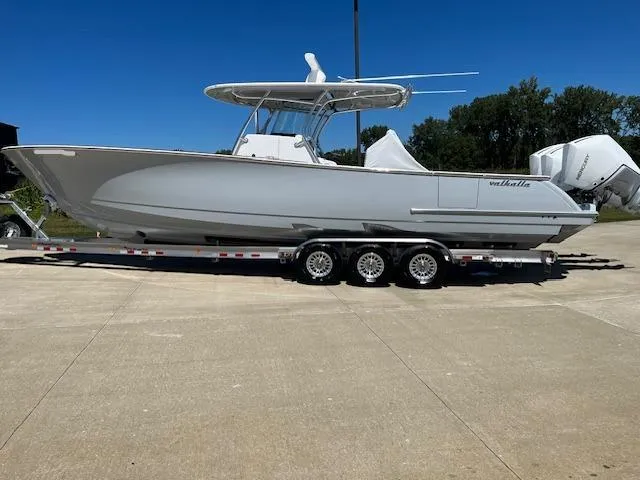 Slide: The Image of 2022 Valhalla Boatworks V 37 on trailer, sleek design, triple engines, outdoor setting. - 8