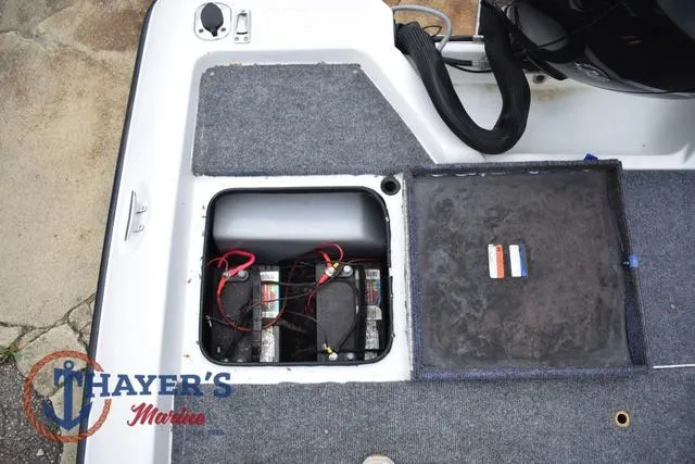 Slide: The Image of Battery compartment of a 1997 Pro Craft 180 boat, featuring dual batteries and carpeted flooring. - 30