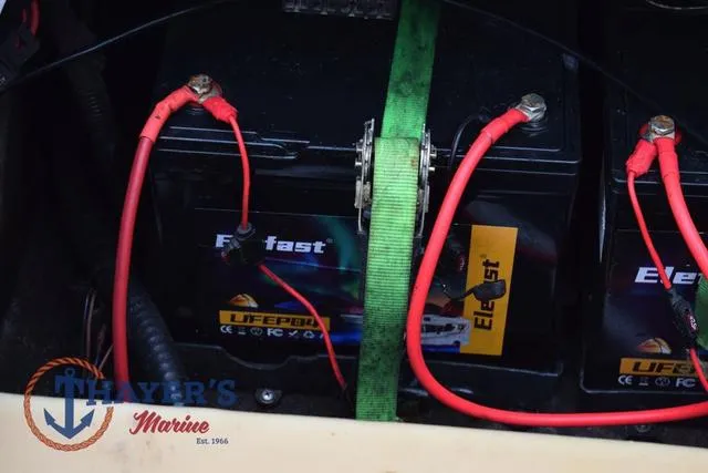 Slide: The Image of Battery setup in a 1997 Pro Craft 180 boat with red cables and green strap. - 33