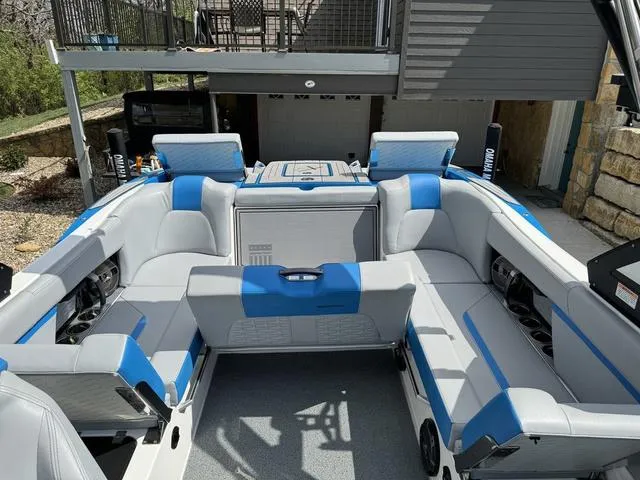 Slide: The Image of 2022 MasterCraft X24 boat interior with blue and gray seating, showcasing spacious and luxurious design. - 10
