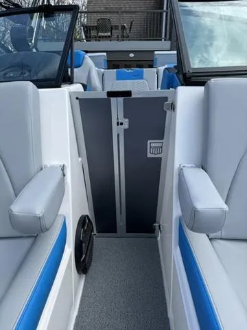 Slide: The Image of 2022 MasterCraft X24 boat interior with gray and blue seating, open windshield, and modern design. - 11