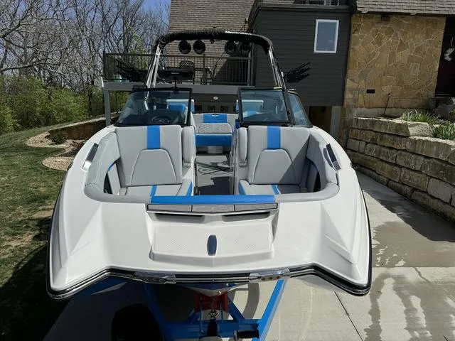 Slide: The Image of 2022 MasterCraft X24 boat with blue accents, parked on a driveway. - 14