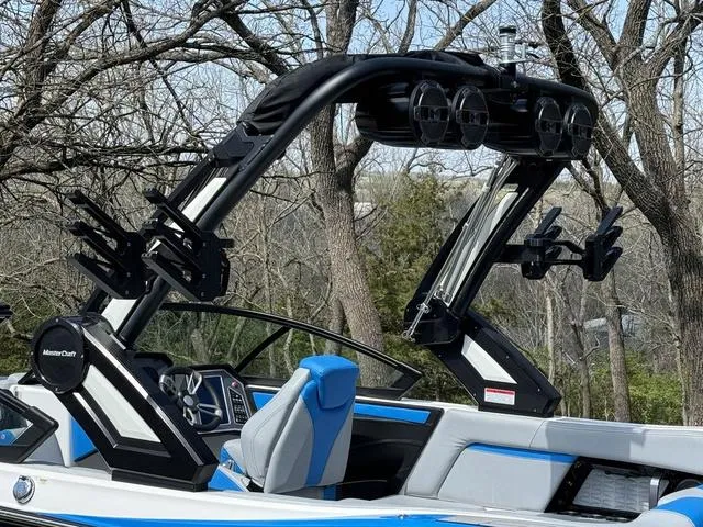 Slide: The Image of 2022 MasterCraft X24 boat with sleek design and advanced features, set against a wooded backdrop. - 15