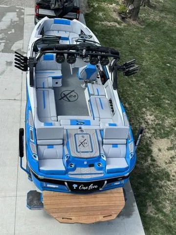Slide: The Image of 2022 MasterCraft X24 boat, blue and white, parked on driveway, top view. - 3
