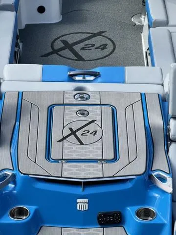 Slide: The Image of 2022 MasterCraft X24 boat interior with blue and gray design, featuring logo and seating. - 7