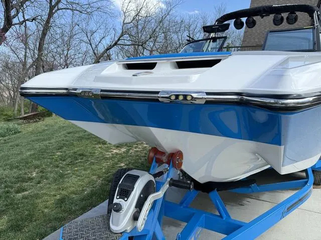 Slide: The Image of 2022 MasterCraft X24 boat on trailer, blue and white design, parked outdoors. - 8