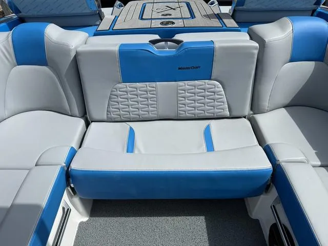 Slide: The Image of 2022 MasterCraft X24 boat interior with blue and gray seating, showcasing modern design and comfort. - 9