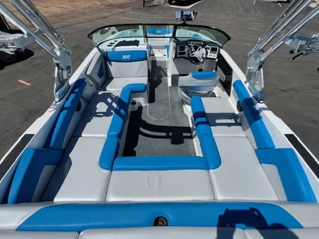 Slide: The Image of 2018 MasterCraft NXT22 boat interior with blue and gray seating, open layout, and modern dashboard. - 10