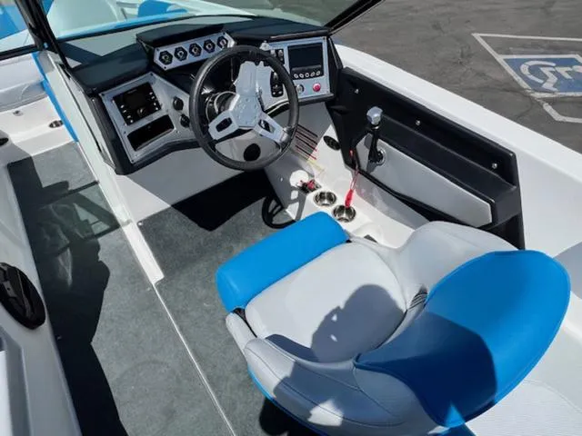 Slide: The Image of 2018 MasterCraft NXT22 boat interior with steering wheel, dashboard, and blue-accented captain's chair. - 11