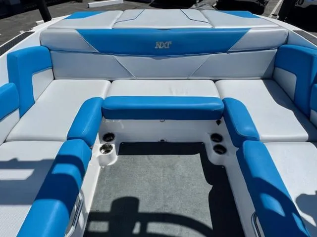 Slide: The Image of 2018 MasterCraft NXT22 boat interior with blue and white seating arrangement. - 14