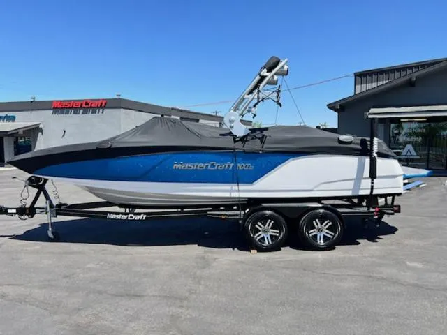 Slide: The Image of 2018 MasterCraft NXT22 boat on trailer, covered, parked outside dealership. - 21