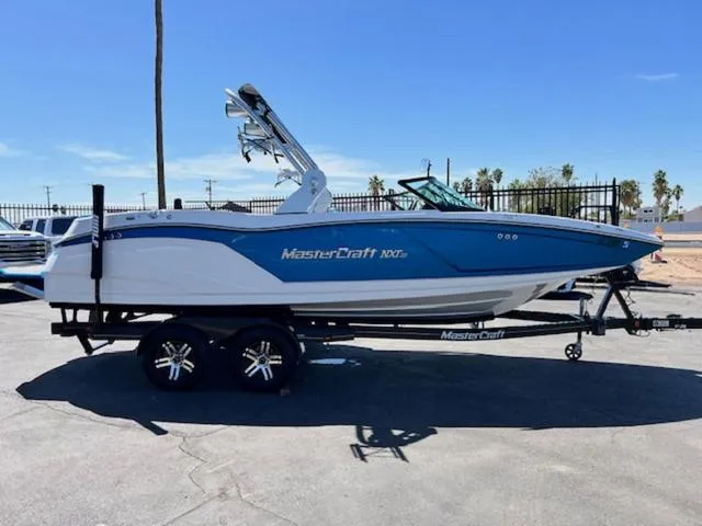 Slide: The Image of 2018 MasterCraft NXT22 boat on trailer, blue and white design, parked outdoors. - 5