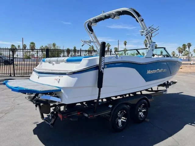 Slide: The Image of 2018 MasterCraft NXT22 boat on trailer, blue and white design, parked outdoors. - 6