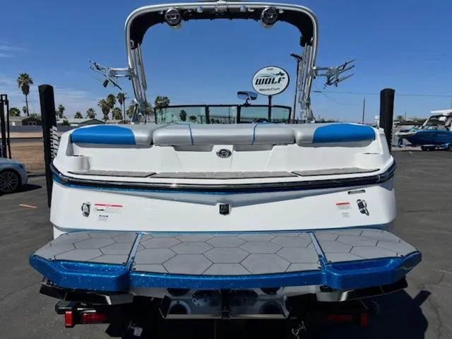 Slide: The Image of 2018 MasterCraft NXT22 boat, rear view, blue and white design, parked outdoors. - 7