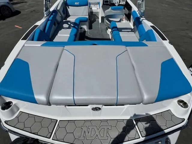 Slide: The Image of 2018 MasterCraft NXT22 boat with blue and gray seating, viewed from the rear deck. - 9