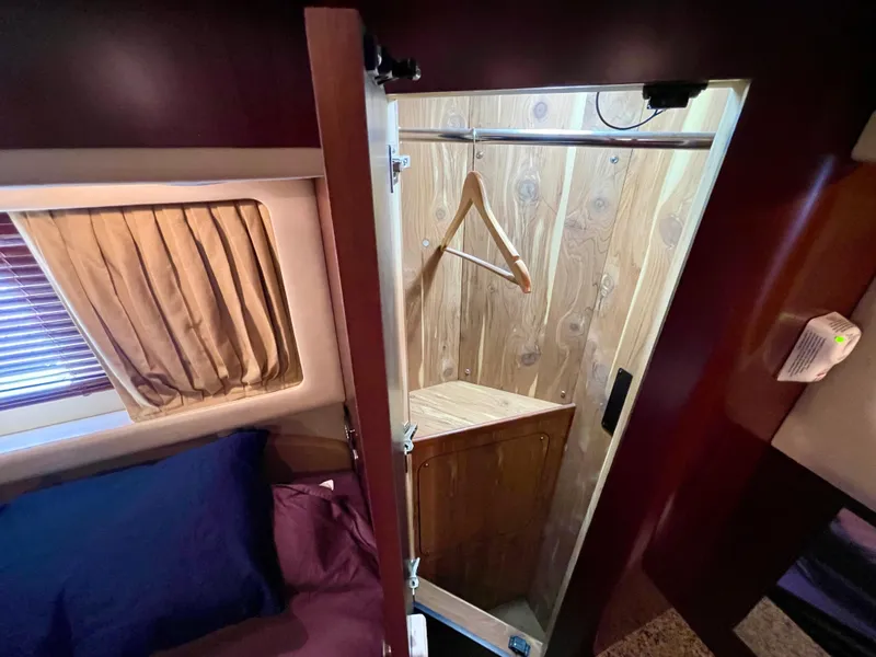 Slide: The Image of 2005 Sea Ray Motor Yacht interior with open wooden closet and bed. - 28