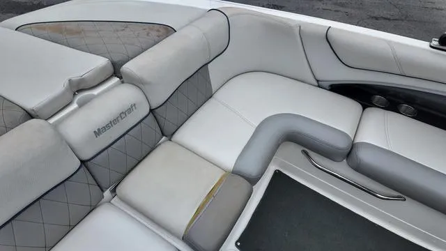 Slide: The Image of 2011 MasterCraft X45 boat interior with white and gray seating, featuring quilted design. - 12