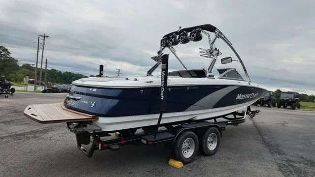 Slide: The Image of 2011 MasterCraft X45 boat on trailer, blue and white design, parked outdoors. - 5