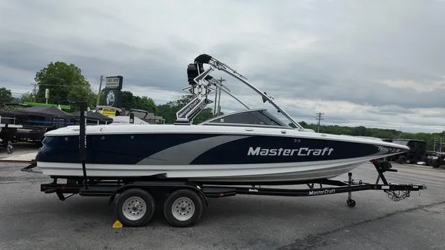 Slide: The Image of 2011 MasterCraft X45 boat on trailer, parked outdoors under cloudy sky. - 6