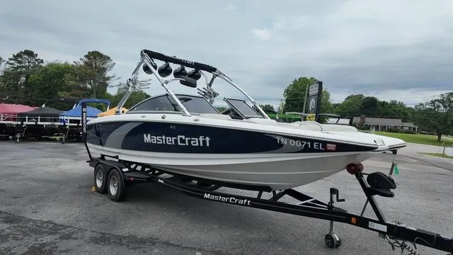 Slide: The Image of 2011 MasterCraft X45 boat on trailer, parked outdoors, showcasing sleek design and branding. - 7