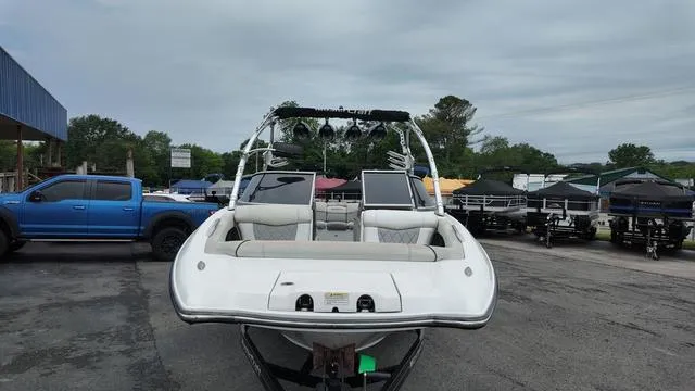 Slide: The Image of 2011 MasterCraft X45 boat on trailer in parking lot, surrounded by vehicles and trees. - 8