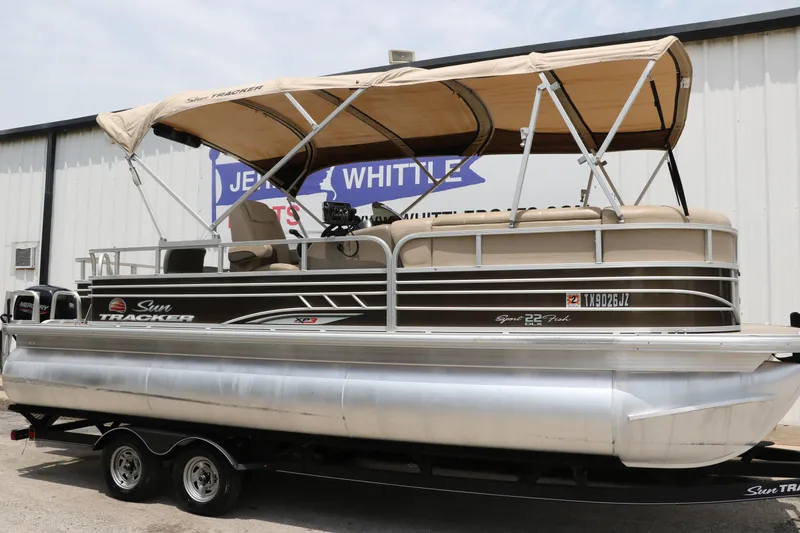 Slide: The Image of 2020 Sun Tracker SportFish 22 XP3 pontoon boat with canopy, parked on a trailer. - 12