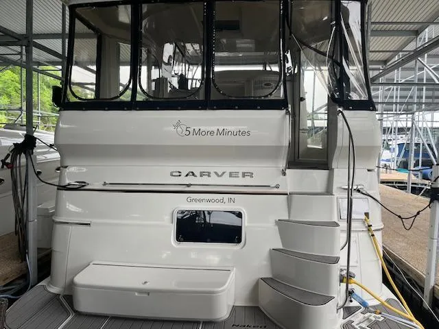 Slide: The Image of 2005 Carver 46 Motor Yacht docked, featuring steps and "5 More Minutes" name. - 12