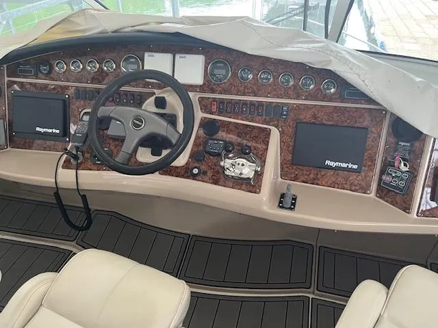 Slide: The Image of 2005 Carver 46 Motor Yacht helm with Raymarine navigation systems and luxurious wood finish. - 14