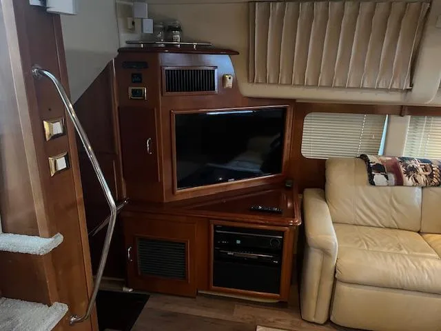 Slide: The Image of Interior of 2005 Carver 46 Motor Yacht with TV, beige sofa, and wooden cabinetry. - 17