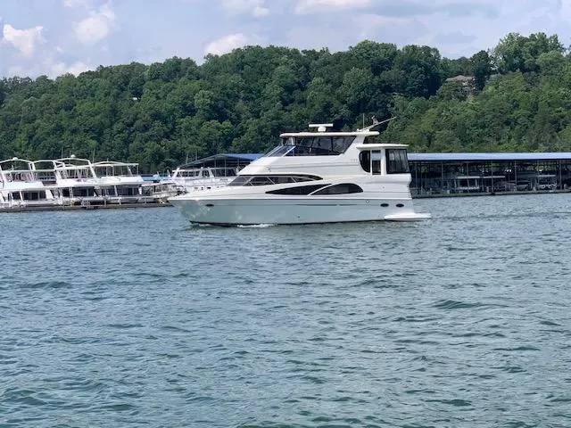 Slide: The Image of 2005 Carver 46 Motor Yacht cruising on a lake near a marina. - 2