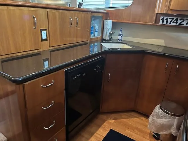 Slide: The Image of 2005 Carver 46 Motor Yacht kitchen with wood cabinets, black countertop, and built-in appliances. - 22