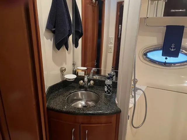 Slide: The Image of 2005 Carver 46 Motor Yacht bathroom with sink, mirror, and porthole window. - 25