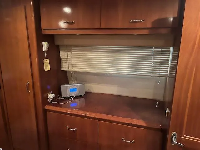 Slide: The Image of 2005 Carver 46 Motor Yacht interior with wooden cabinetry and a small electronic device. - 27